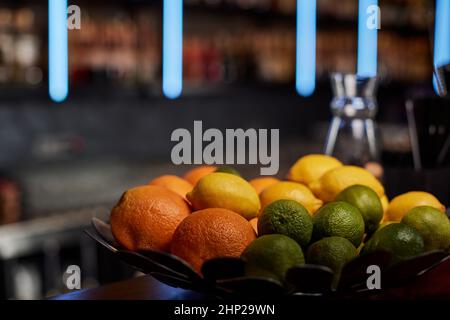 piatto con limoni, lime e arance sul bancone bar Foto Stock