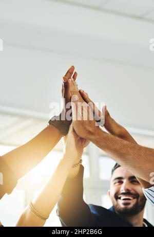 Motivato più che mai. Scatto corto di un gruppo di uomini d'affari alto che si fiving in un ufficio. Foto Stock