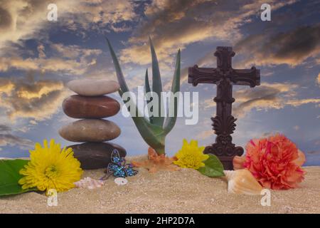 Croce e fiori su sabbia con pianta di Aloe vera Foto Stock