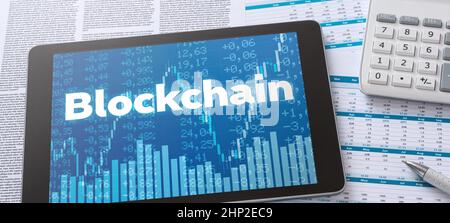 Un tablet con documenti finanziari - Blockchain Foto Stock