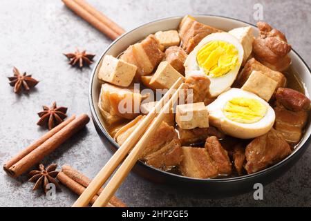 Kai Palo la popolare cucina tailandese ha un menu facile che serve uova sode e pancia di maiale e tofu su brodo di soia closeup nella ciotola sul tavolo. Horizo Foto Stock