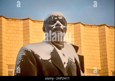 Busto di Vladimir Lenin sullo sfondo di un edificio bianco polverato di neve Foto Stock