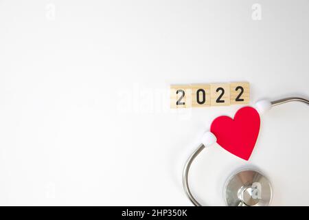 Stetoscopio con 2022 isolato su sfondo bianco. Felice anno nuovo per assistenza sanitaria e banner medico calendario copertina. Idea creativa per una nuova tendenza in m Foto Stock