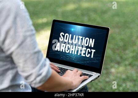 Firma visualizzazione di Solution Architect, approccio aziendale progettazione di applicazioni o servizi all'interno di un'organizzazione Woman Typing on laptop sitting outside Ba Foto Stock