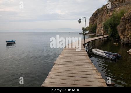 Pontile in legno su un lago e una barca. Foto Stock