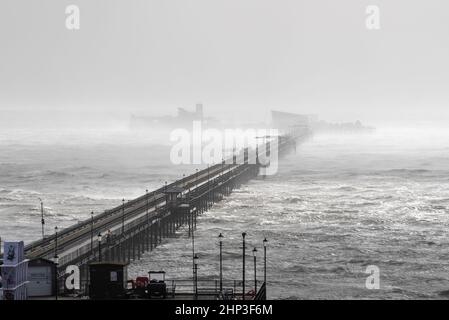 Southend on Sea, Essex, Regno Unito. 18th Feb 2022. Storm Eunice ha colpito la città estuario del Tamigi causando danni e attirando la gente verso il lungomare. Southend Pier in mare aperto Foto Stock