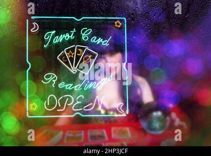 Letture di carte Tarocchi Neon Sign in Window with Psychic Tarot Card Reader Blurred in background Foto Stock