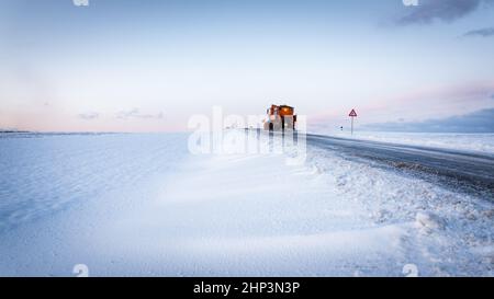 Spazzaneve su strada di salatura autostradale . Strada di scongelamento del carrello arancione. Manutenzione veicolo invernale ampio panorama o banner. Foto Stock