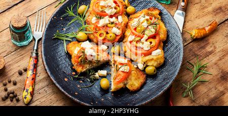 Sottile strato di carne, impanato in pangrattato con formaggio, olive e pomodoro. Piatto di carne - schnitzel Foto Stock