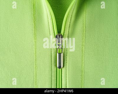 Chiusura lampo di felpa verde chiaro con cappuccio in primo piano. Elegante giacca estiva in cotone con chiusura zip. Abiti alla moda in colori luminosi. Foto Stock