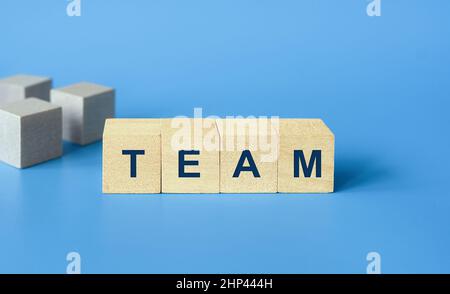 Concetto aziendale di team, blocchi di legno cubo con testo team su sfondo blu Foto Stock