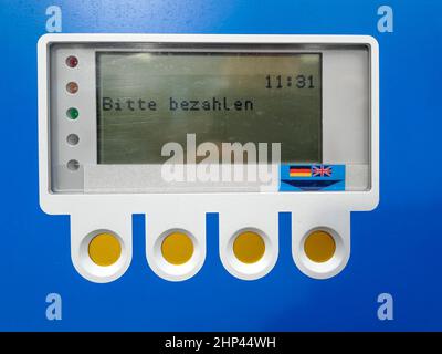 Pannello di controllo LCD e tasti funzione di un parchimetro blu con il prompt pagamento richiesto in lingua tedesca Foto Stock