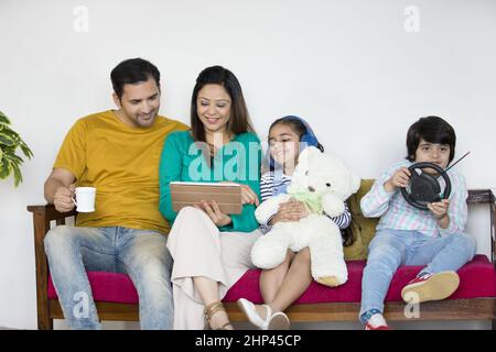 Piccola famiglia nucleare in India - famiglia felice che passa il tempo di qualità con l'altro in soggiorno Foto Stock