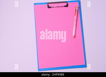 supporto blu con fogli rosa puliti su sfondo viola, vista dall'alto Foto Stock