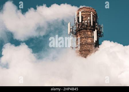 Fumo denso e pesante che esce da un enorme e alto camino chimico fabbrica sotto un cielo blu Foto Stock