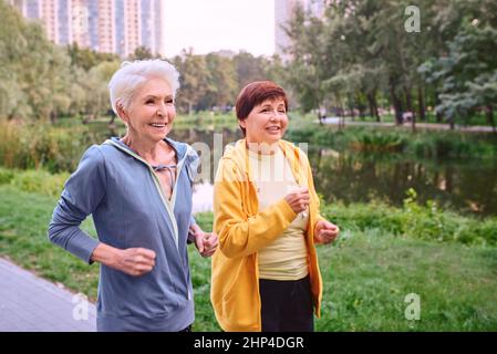 due donne mature che fanno jogging nel parco. concetto di stile di vita sano Foto Stock