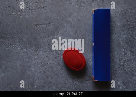 Scatole regalo in velluto rosso e blu da vicino su sfondo grigio con posto per il testo Foto Stock