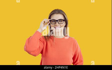 Ritratto di giovane donna con bel sorriso con occhiali isolati su sfondo giallo. Foto Stock