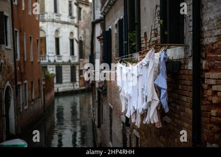 La lavanderia è appesa al muro di una casa in un piccolo canale di Venezia. Foto Stock