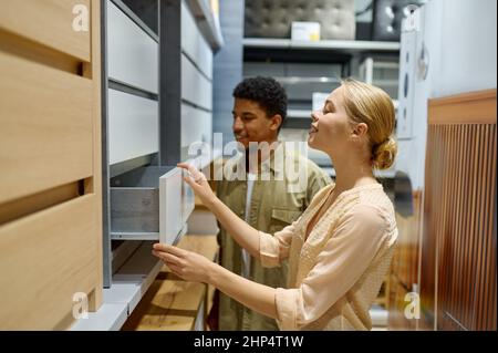 Coppia interracial che sceglie i nuovi mobili della cucina di armadietti nel deposito che guarda i particolari Foto Stock