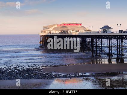 L'iconico molo Cromer (Norfolk) in bassa luce solare invernale, gennaio 2021 in mari tranquilli su una marea bassa Foto Stock