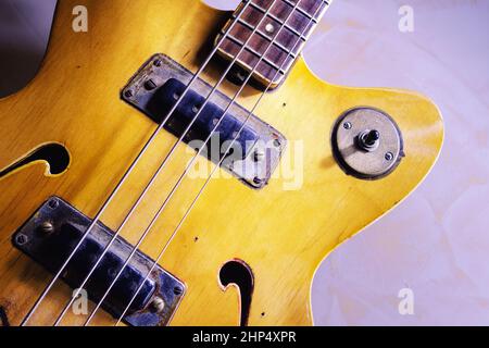 Dettagli di una vecchia chitarra basso elettrica in stile vintage, modello ad arco con f fori. Foto Stock