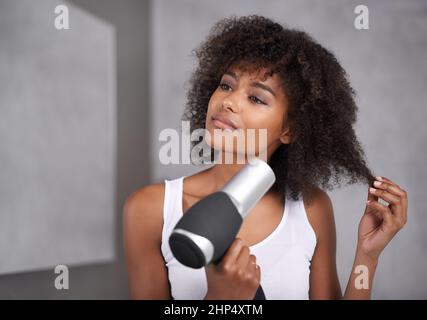 Dando ai capelli il trattamento completo del corso. Scatto di una giovane donna attraente che si prende cura dei suoi capelli. Foto Stock