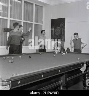 1950s, apprendisti storici, giovani maschi che hanno una pausa nel club sociale di opere, due che giocano un gioco di biliardo, gli altri che hanno un gioco di freccette, Steel Company of Wales, Abbey Works, Port Talbot, Wales, UK. Foto Stock