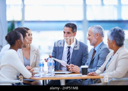 Prendere importanti decisioni aziendali nella sala riunioni. Un'immagine ritagliata di un gruppo diversificato di uomini d'affari che hanno una riunione. Foto Stock