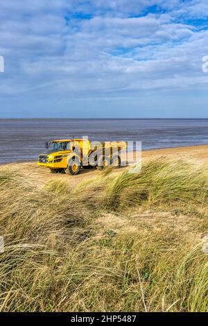 Autocarro Volvo A30G che esegue lavori di restauro della linea costiera sulla riva del lavaggio a Snettisham spiaggia, Norfolk. Foto Stock