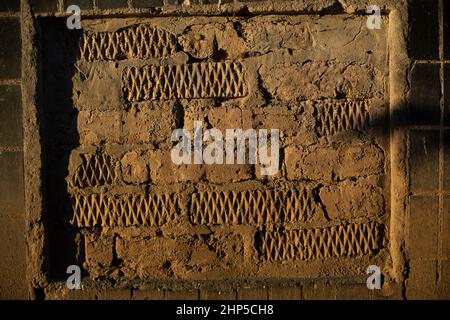 Dettagli del vecchio muro. Passaggio bricked. La finestra è chiusa con cemento. Luce solare sulla superficie della parete. Foto Stock