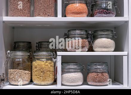 Vasetti di vetro con pasta, cereali vari e cereali. Concetto di conservazione degli alimenti . Foto Stock