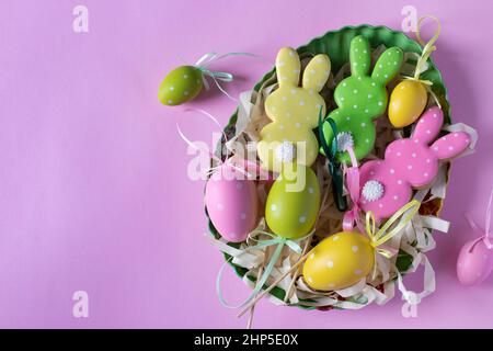 Pan di zenzero di Pasqua sotto forma di conigli e uova carini su sfondo rosa. Festa primaverile della chiesa. Spazio per il testo Foto Stock