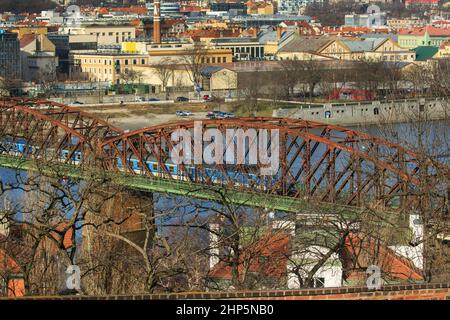 Locomotiva di classe 162 delle Ferrovie ceche di Ceske Drahy che attraversano il fiume Moldava, con archi in ferro rosso o acciaio sul ponte, Praga, repubblica Ceca Foto Stock