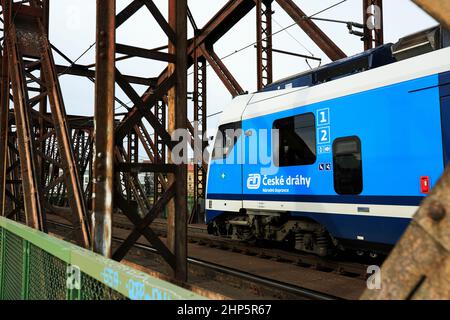 Locomotiva di classe 162 delle Ferrovie ceche di Ceske Drahy che attraversano il fiume Moldava, con passerella pedonale in legno oltre ai binari, Praga, repubblica Ceca Foto Stock