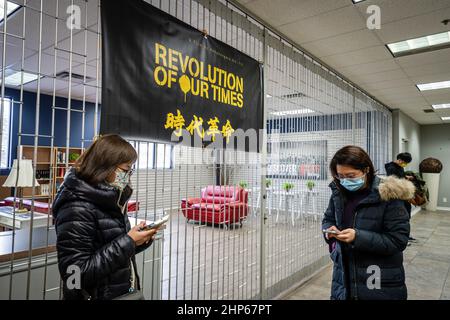 Toronto, Canada. 18th Feb 2022. La gente ha visto al telefono sotto una bandiera 'Rivoluzione dei nostri tempi'.Toronto HK Club ospita una proiezione della 'Rivoluzione dei nostri tempi' un documentario controverso sulle 2019-2020 proteste di Hong Kong dirette da Kiwi Chow, a Toronto, Canada. Prima premiazione ad una sorpresa che mostra al Festival di Cannes, i biglietti sono stati venduti in proiezioni in tutto il Canada mentre sono stati vietati in Cina e Hong Kong. Credit: SOPA Images Limited/Alamy Live News Foto Stock