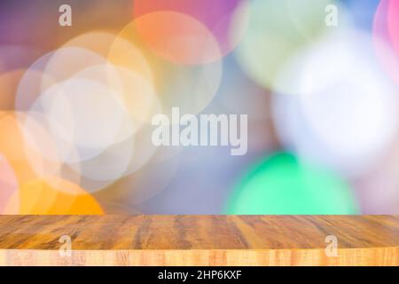 Lungo e moderno bancone in legno vuoto sulla parte superiore per posizionare oggetti e qualsiasi cosa su sfondo bokeh chiaro multicolore sfocato Foto Stock