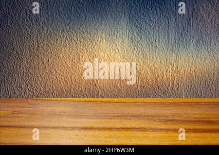 Tavola vuota di legno di fronte a parete naturale con scarsa illuminazione Foto Stock