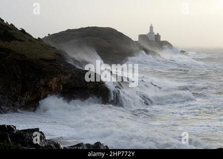 Tempesta Eunice ai Mumbles. Swansea, Galles, Regno Unito. Le onde si infrangono sul faro e sul promontorio e 90mph venti frustano lo spray Foto Stock