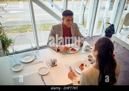 sorridendo i colleghi che pranzano presso la caffetteria dell'ufficio Foto Stock