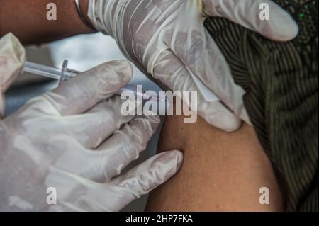 Medan, Indonesia. 19th Feb 2022. Un operatore sanitario inocula una donna con una dose di richiamo del vaccino COVID-19 a Medan, Sumatra settentrionale, Indonesia, 19 febbraio 2022. Credit: Sutanta Aditya/Xinhua/Alamy Live News Foto Stock