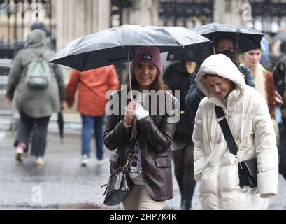 I membri del pubblico rinforzano il vento e il tempo umido nel centro di Westminster a Londra, seguendo Storm Eunice. Data immagine: Venerdì 18 febbraio 2022. Foto Stock