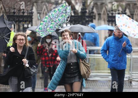 I membri del pubblico rinforzano il vento e il tempo umido nel centro di Westminster a Londra, seguendo Storm Eunice. Data immagine: Venerdì 18 febbraio 2022. Foto Stock