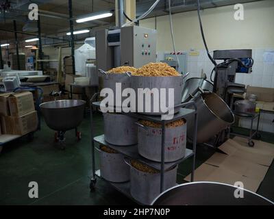 Produzione di chak-chak alla panetteria su scala industriale. Prodotto nazionale del Tatar . Una pentola enorme di chak-chak Foto Stock