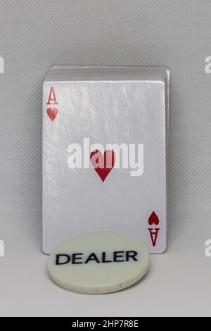 Un mazzo di carte da poker con una targa recante il mazziere di iscrizione. C'è un asso di cuori sulla carta. Foto Stock