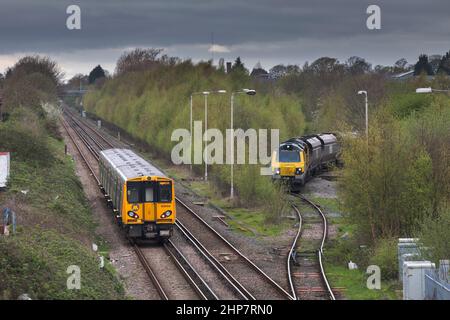 Merseyrail electrics classe 508 passando una locomotiva diesel Freightliner classe 70 in attesa di scendere dalla diramazione Ellesmere portuale al porto di Ellesmere. Foto Stock