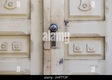 Vecchia porta bianca. Sulla porta è presente una serratura e una maniglia a forma di sfera. Foto Stock