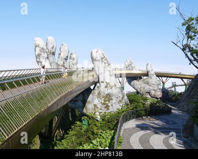 Da Nang, Vietnam - 12 aprile 2021: Golden Bridge sollevato da mani giganti in Ba Na Hills, un famoso parco a tema e resort nel Vietnam centrale Foto Stock