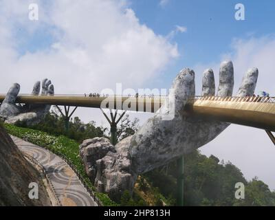 Da Nang, Vietnam - 12 aprile 2021: Golden Bridge sollevato da mani giganti in Ba Na Hills, un famoso parco a tema e resort nel Vietnam centrale Foto Stock