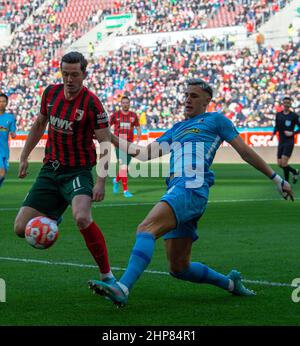 Augusta, Germania. 19th Feb 2022. Calcio: Bundesliga, FC Augsburg - SC Friburgo, Matchday 23 alla WWK Arena. Michael Gregoritsch (l) di Augusta e Nico Schlotterbeck di Friburgo lottano per la palla. Credit: Stefan Puchner/dpa - NOTA IMPORTANTE: In conformità con i requisiti della DFL Deutsche Fußball Liga e della DFB Deutscher Fußball-Bund, è vietato utilizzare o utilizzare fotografie scattate nello stadio e/o della partita sotto forma di immagini di sequenza e/o serie di foto video-simili./dpa/Alamy Live News Foto Stock